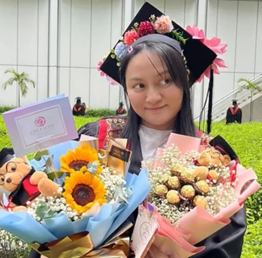 Graduate with floral bouquets and teddy bears