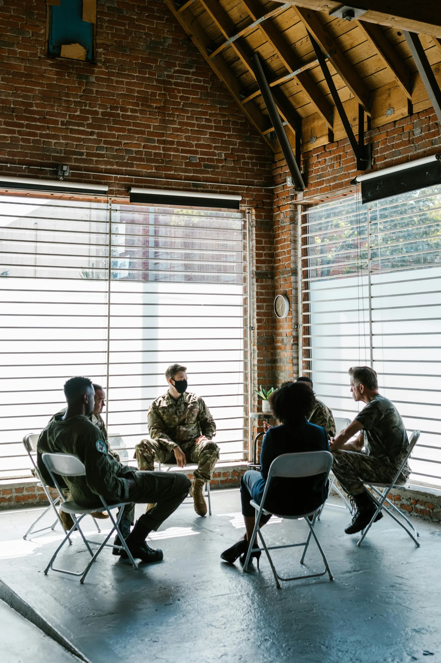 Group discussion among military personnel indoors.