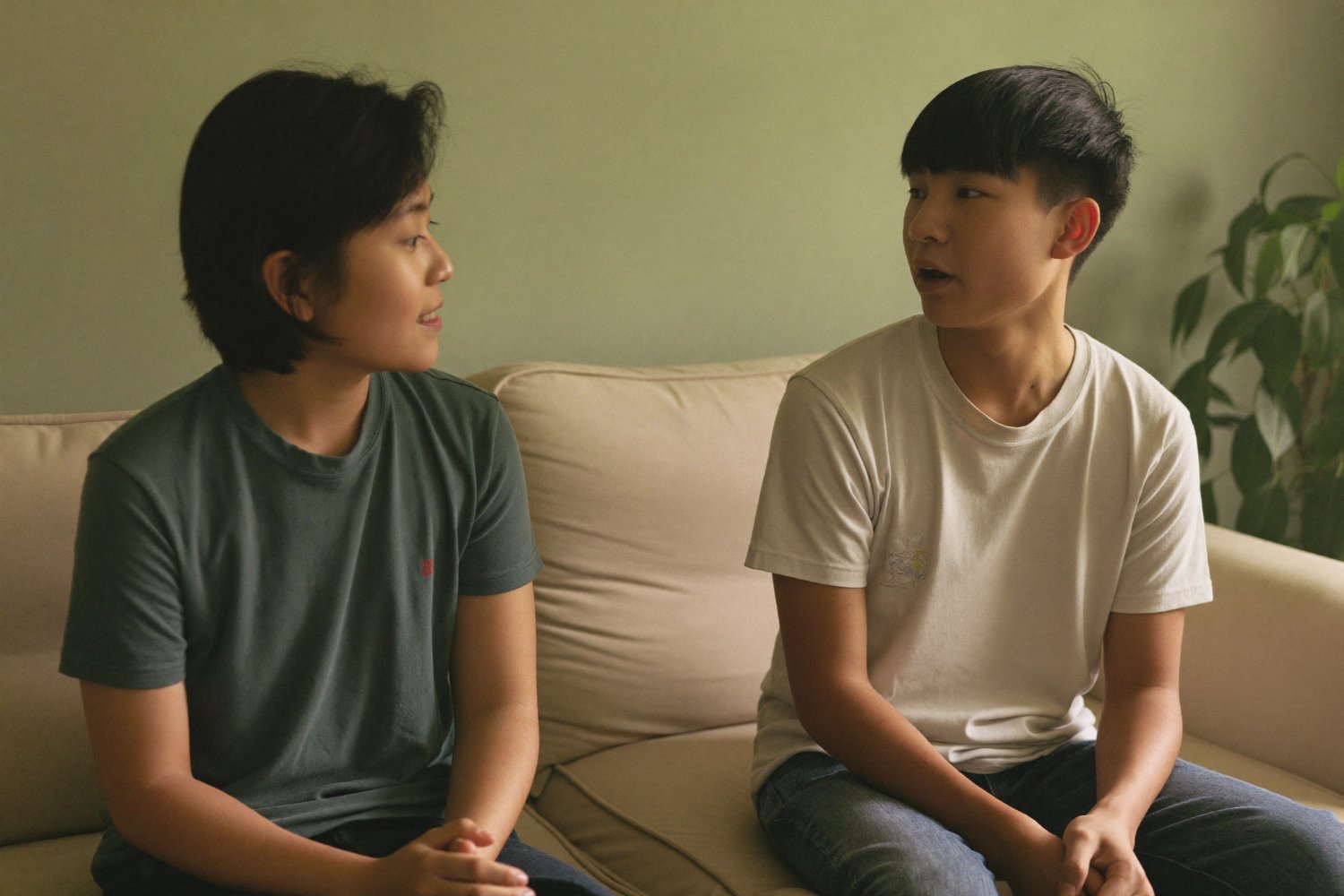 Two family members sitting together on a sofa in a calm conversation at home