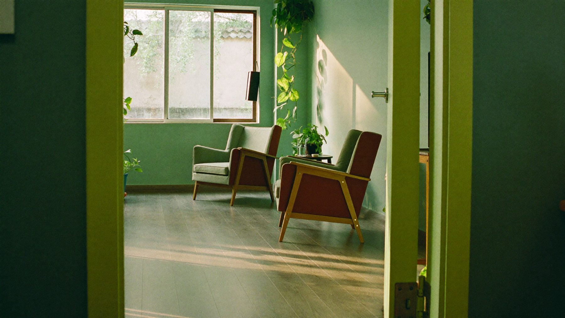 A calm therapy room with two armchairs and plants at BeLive in Psychology, Damansara Perdana