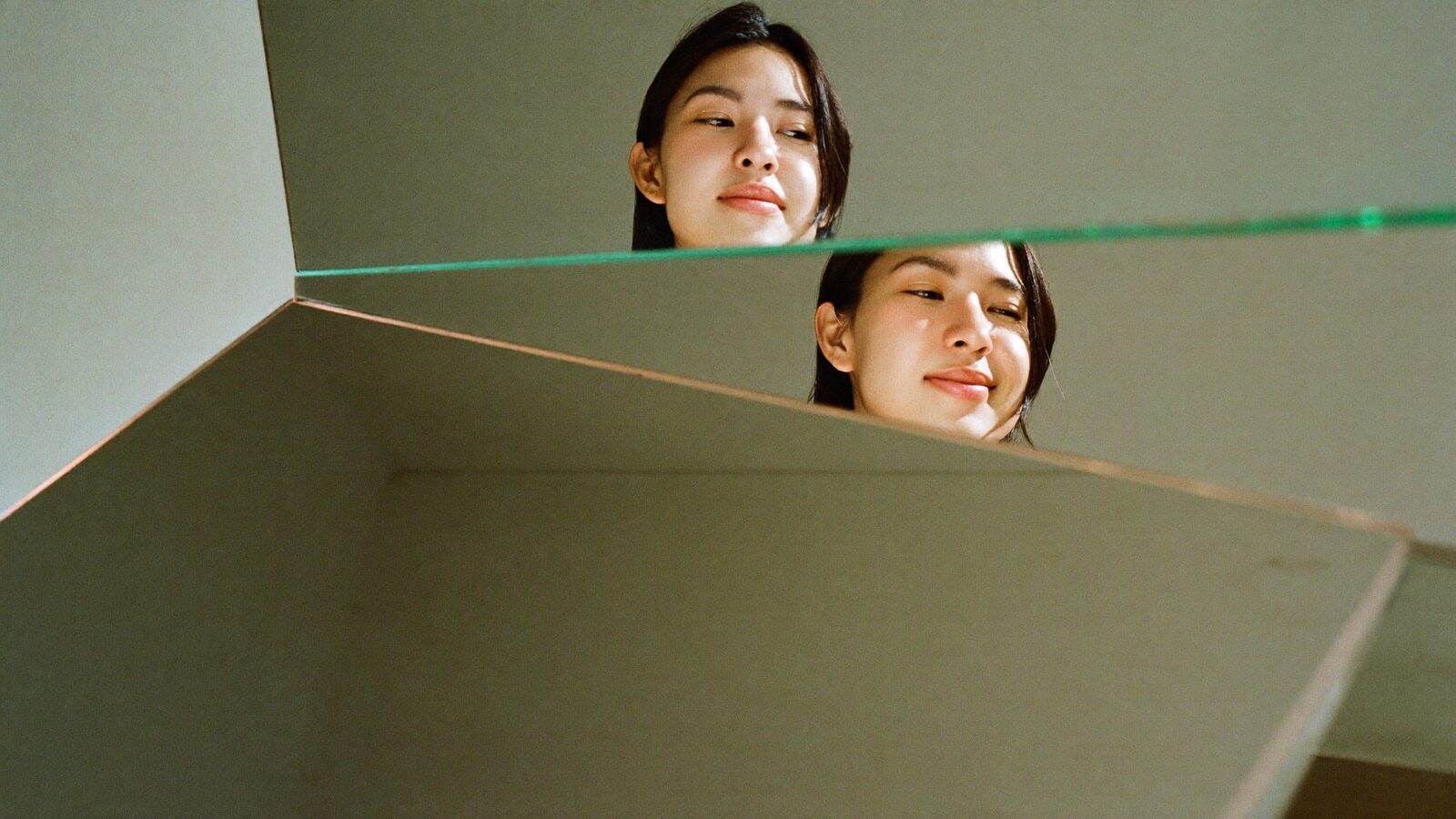 A woman's face reflected at different angles in a set of mirrors, each showing a different expression