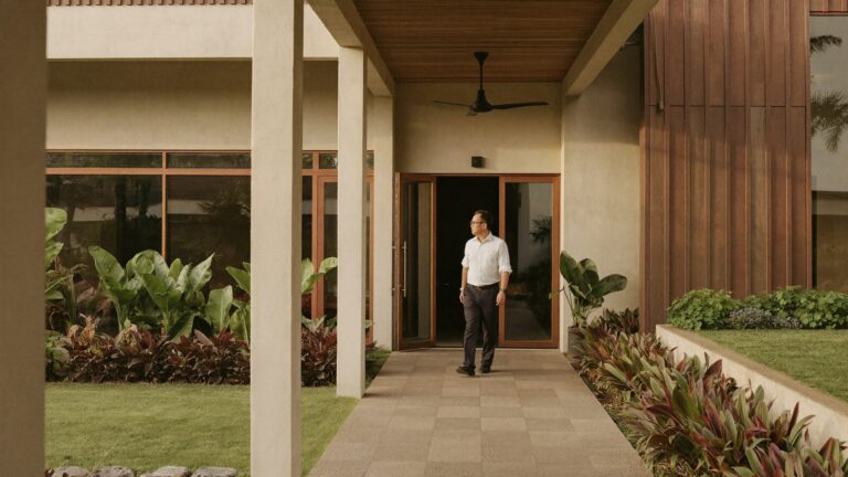 A man pausing outside a Malaysian building, weighing up government and private mental health clinics